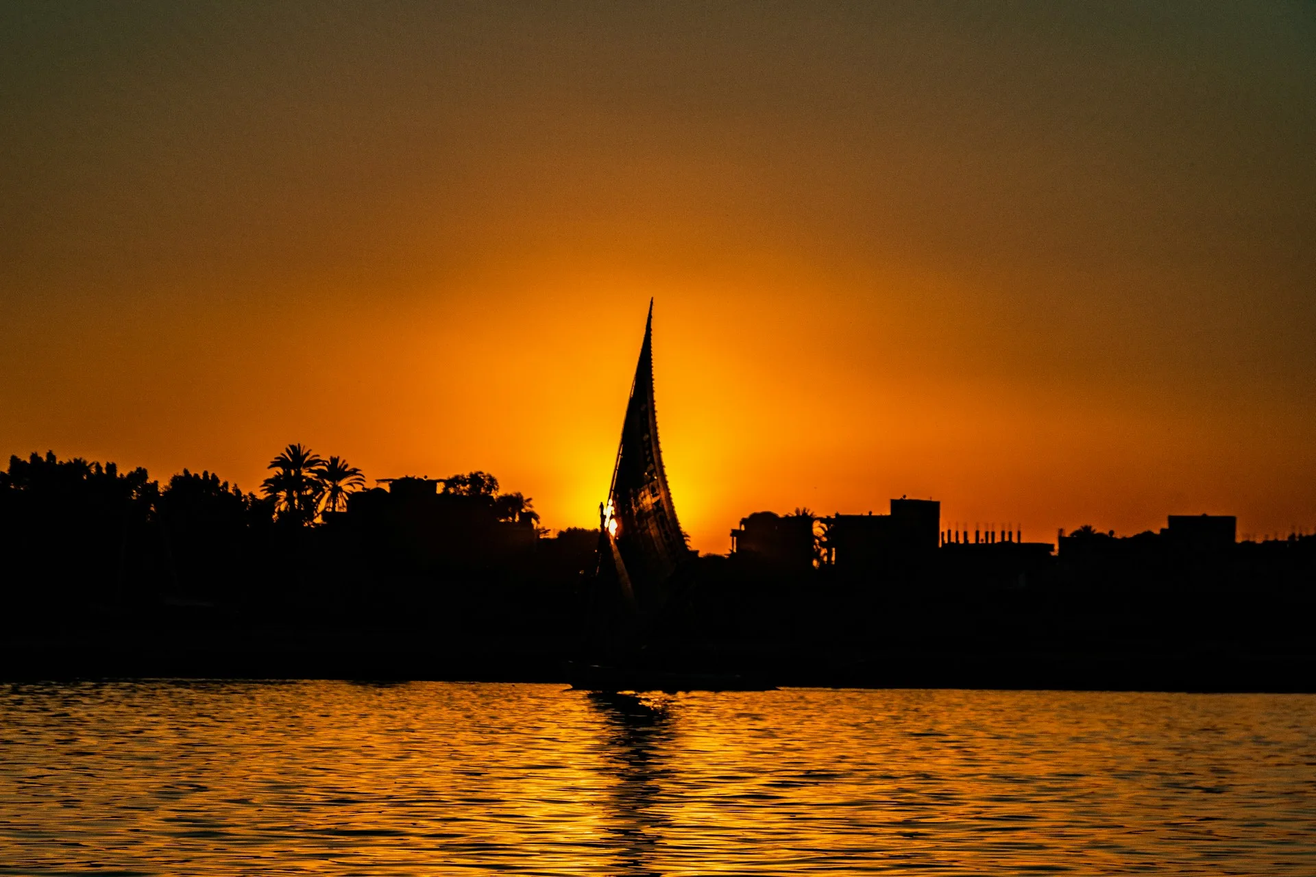 A traditional cruise boat sailing the Nile past golden desert banks