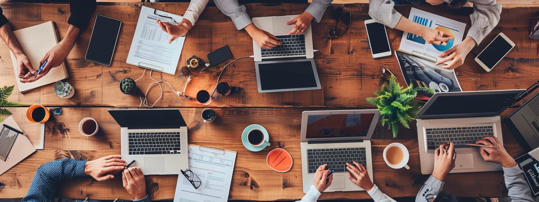 a business team gathered around a table in an office, discussing travel package options with laptops and documents scattered around, showcasing a collaborative decision-making process for their upcoming trip to cleveland.